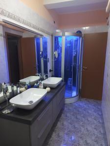 a large bathroom with two sinks and a shower at Trilocale moderno a 10 min dalla Metro Gessate in Gessate +8 photos