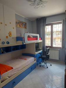 a bedroom with a bunk bed and a desk and a chair at Trilocale moderno a 10 min dalla Metro Gessate in Gessate