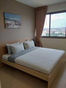 Una cama grande en un dormitorio con una ventana grande. en Large High Floor, Best Pool and Great Location, en Pattaya South