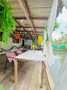 a dining table on a deck next to the water at Lungkluay homestay in Ko Kood