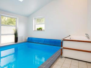 a swimming pool in a room with a tub and windows at 12 person holiday home in Væggerløse-By Traum in Marielyst