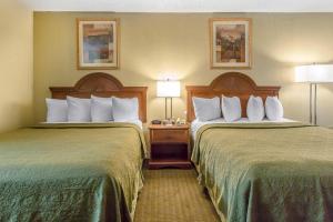 a hotel room with two beds and two lamps at OYO Travelers Inn in Lawton +32 photos