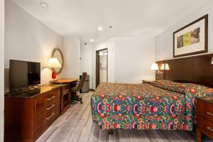 a hotel room with a bed and a flat screen tv at Paradise Lodge - Canoga Park, Los Angeles in Winnetka