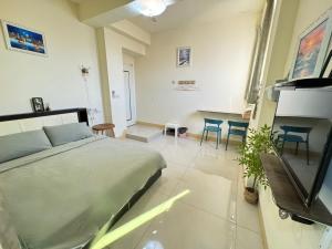 a bedroom with a bed and a table and chairs at 大橋旁民宿 in Jincheng