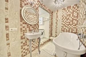 Juozapaviciaus apartments في فيلنيوس: حمام مع حوض ومرآة