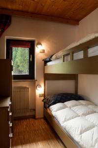 a bedroom with two bunk beds and a window at Casa al Lago di Carezza - Dolomiti in Carezza al Lago