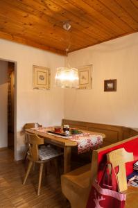 a dining room with a table and a chandelier at Casa al Lago di Carezza - Dolomiti in Carezza al Lago