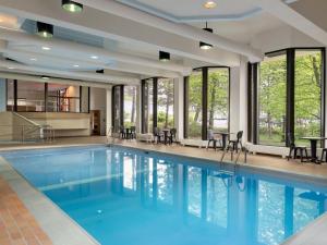 une grande piscine avec des chaises et des fenêtres dans l'établissement Travelodge by Wyndham Sydney, à Sydney