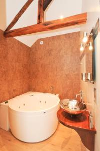 a large white tub in a bathroom with a sink at Chambre d'Hotes de la Loge in Moussy +13 photos