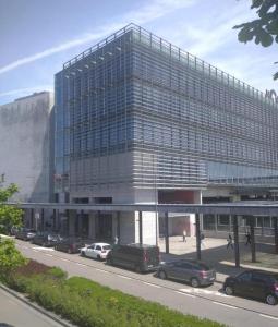 a large glass building with cars parked in front of it at Blue Orange Porto Apart in Porto