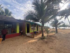 a house on the beach with palm trees next to it at Coco beach front stay in Gokarn