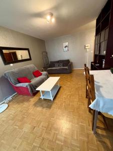 a living room with a couch and a table at Tram 50 m, Balcon, Parking facile in Saint-Priest