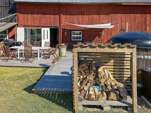 a pile of fire wood next to a house at 9 person holiday home in Tystberga in Tystberga +14 photos