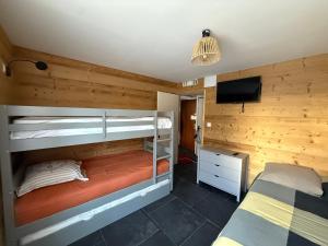 1 Schlafzimmer mit 2 Etagenbetten und einem Flachbild-TV in der Unterkunft Appartement au pied des pistes Serre chevalier in La Salle Les Alpes