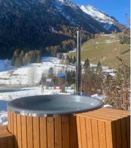 una vasca idromassaggio su una terrazza con una montagna innevata di La casetta di Piera a Brusson