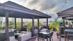 a patio with tables and chairs on a roof at Tropical Enclave Hotel in Accra