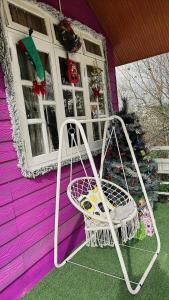 a white chair sitting outside of a purple house at Nhà MIO in Khu Chi Lăng