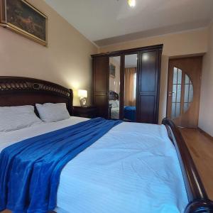 a bedroom with a large bed with a blue blanket at Санта Барбара in Lviv
