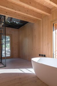 a bath tub in a room with a wooden ceiling at Maso Stregozzi - Valorz in Rabbi +80 photos