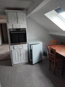 a kitchen with a stove and a refrigerator and a table at Chez daniel in Damparis