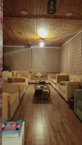 a living room with couches and a coffee table at La Mark Hostel in Wadi Musa
