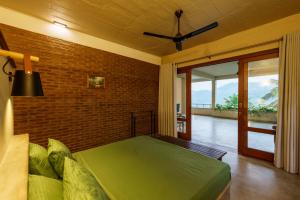 a bedroom with a green bed and a brick wall at Golf Resort Par 3 in Digana +54 photos