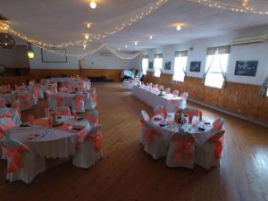 une salle de banquet avec des tables blanches avec des nœuds rouges dans l'établissement Stoco Lake Lodge, à Tweed