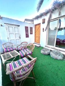 un groupe de chaises et une table sur une terrasse dans l'établissement Palm house, à Dahab