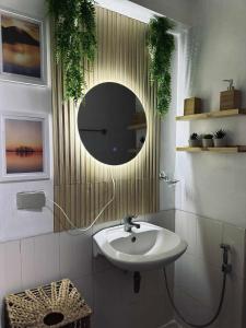 une salle de bain avec un lavabo et un miroir dans l'établissement La Verti Residences Pasay City, à Manille