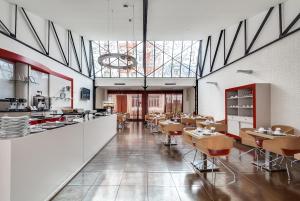 a restaurant with tables and chairs in a room at Pavillon Nation in Paris