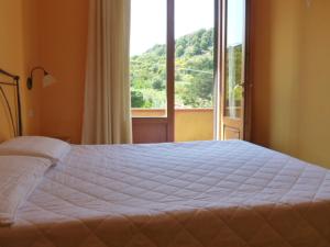 ein Schlafzimmer mit einem großen Bett und einem großen Fenster in der Unterkunft Bed & Breakfast - Anselmi M&M in Marciana