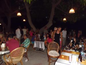 un grupo de personas sentadas en mesas en una fiesta en Deniz Hotel, en Fethiye