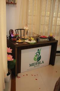 a table with a sign on it in a room at Midhila Marari in Mararikulam