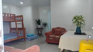 a living room with a table and a chair at Baguio Brentwood Villas in Baguio +3 photos