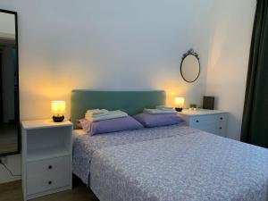 a bedroom with a bed with purple pillows and a mirror at Small apartment in center in Montesilvano
