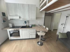 a kitchen with white cabinets and a wooden table at Small apartment in center in Montesilvano +1 photo