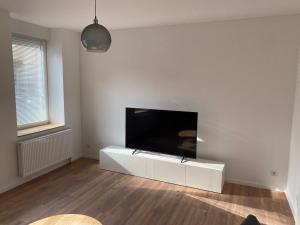 a white living room with a flat screen tv at Heart of Essen in Essen