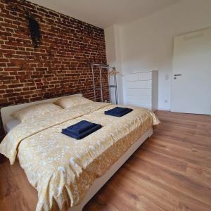 a bedroom with a bed with a brick wall at Heart of Essen in Essen