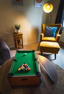 a living room with a pool table and a chair at Sherbet House in Water Orton