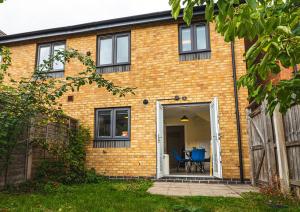a brick house with two blue chairs in the doorway at Sherbet House in Water Orton