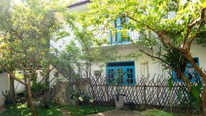 a white house with blue windows and a fence at Blissful House Two Bedroom Apartment Thalpe Beach in Galle