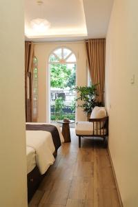 a bedroom with a bed and a window at Maison Maravelle Hotel - Boutique Stay in Hanoi Old Quarter in Hanoi