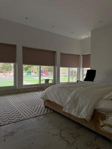 a bedroom with a large bed with a laptop on it at Luxury Farmhouse Near Yas Island With Swimming Pool, BBQ Area & Majlis in Al Rahba +13 photos