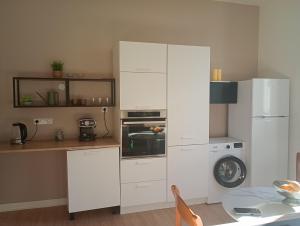 a kitchen with white cabinets and a refrigerator at magnifique T4 centre bayonne in Bayonne