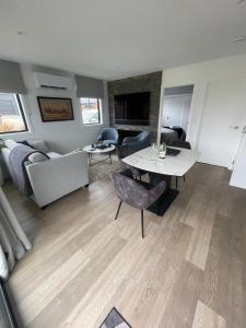 a living room with a table and chairs and a couch at Spa apartment in Queenstown in Queenstown Airport +10 photos