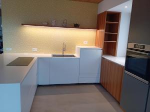 cocina con encimeras blancas, fregadero y fogones en Relaxing accommodation and family, en Flavon