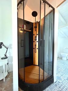 a glass shower in a room with a lamp at La ou je t emmenerai in Laure-Minervois