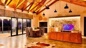Una sala de estar con una mesa y un televisor. en 19 on Idwala, Mabalingwe Game Reserve, en Bela-Bela