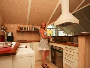 Una mujer está parada en una cocina en 6 person holiday home in Dronningmølle-By Traum, en Gilleleje