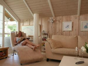 a woman sitting in a chair in a living room at 6 person holiday home in Dronningmølle-By Traum in Gilleleje +14 photos